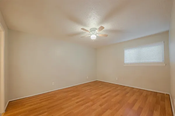 an empty room with a fan and a window