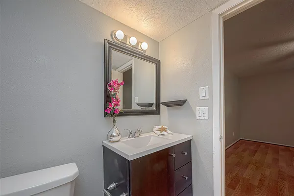 a bathroom with a sink vanity mirror and toilet