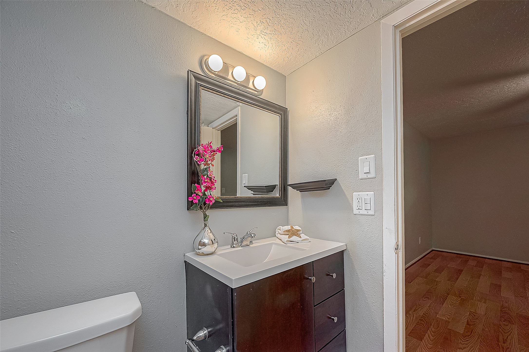 3224 Timmons Lane, Unit 147 Houston, TX 77027 - Photo 20 of 32 a bathroom with a sink vanity mirror and toilet