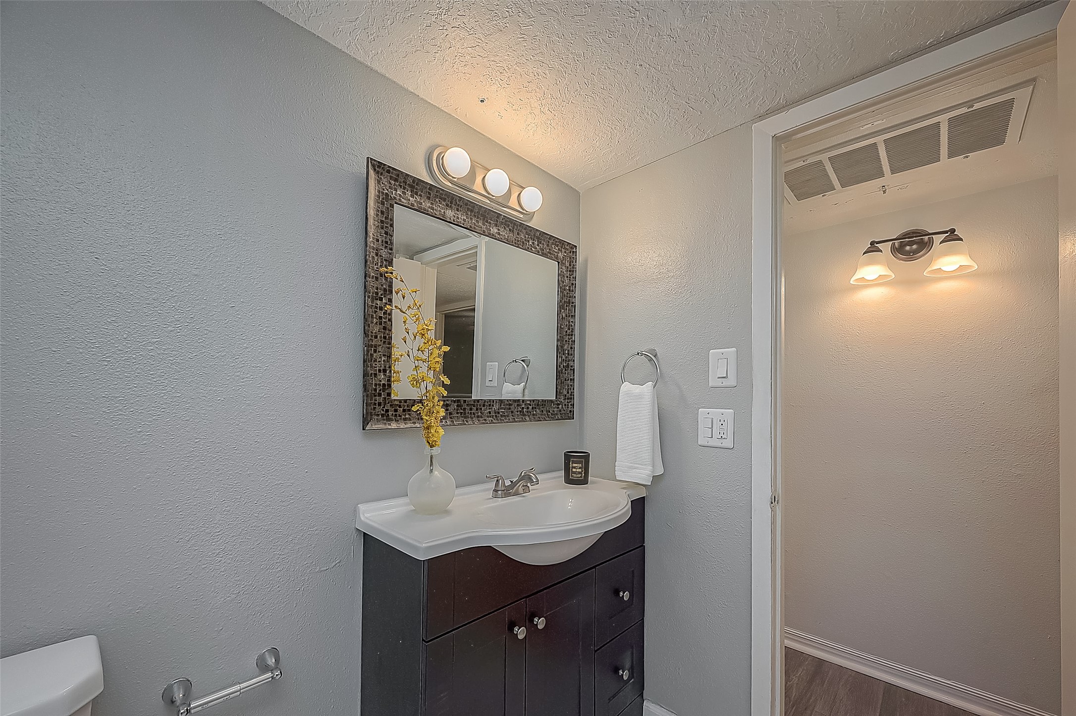 3224 Timmons Lane, Unit 147 Houston, TX 77027 - Photo 23 of 32 a bathroom with a toilet a sink and mirror