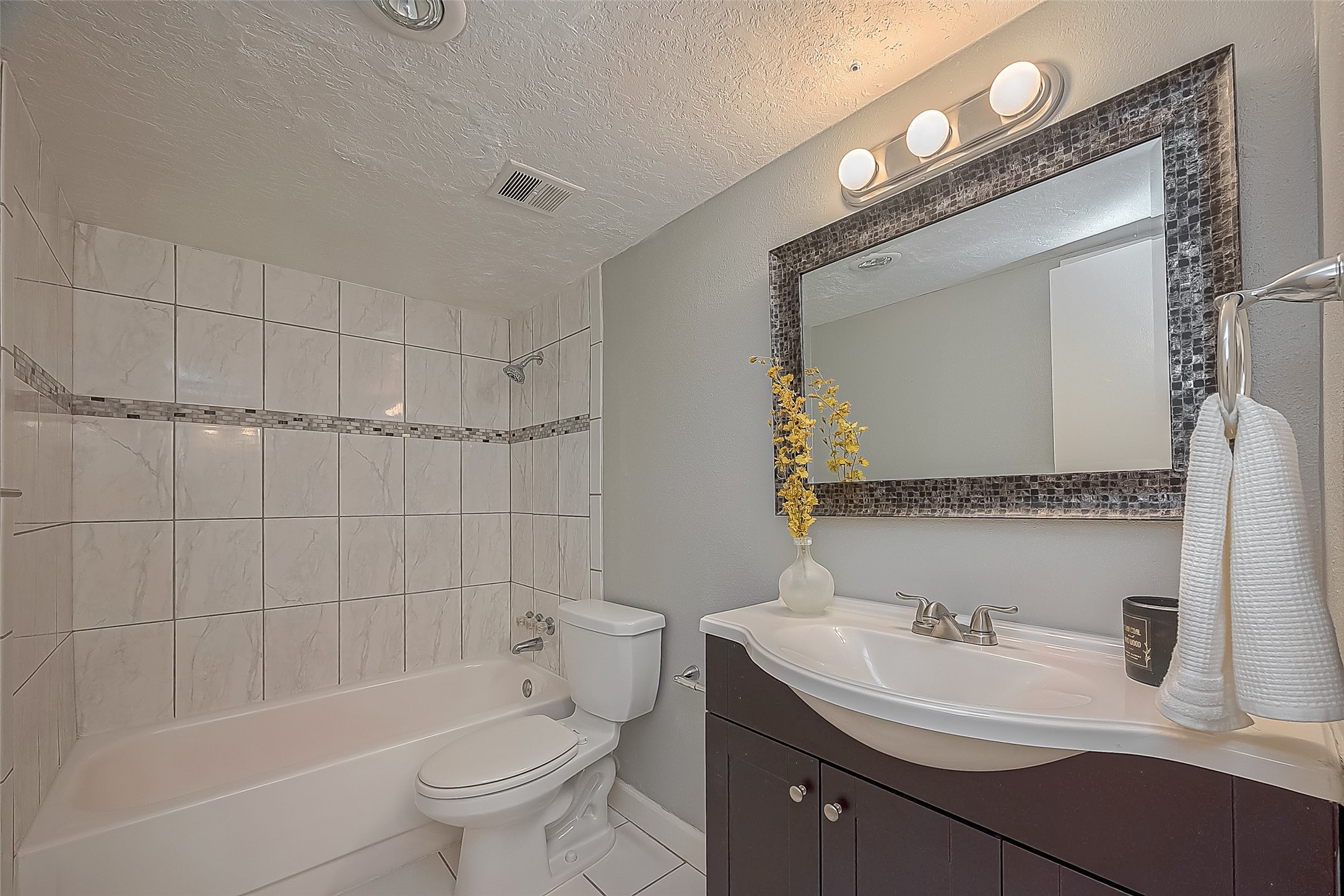 3224 Timmons Lane, Unit 147 Houston, TX 77027 - Photo 24 of 32 a bathroom with a toilet a sink a mirror a bathtub and vanity