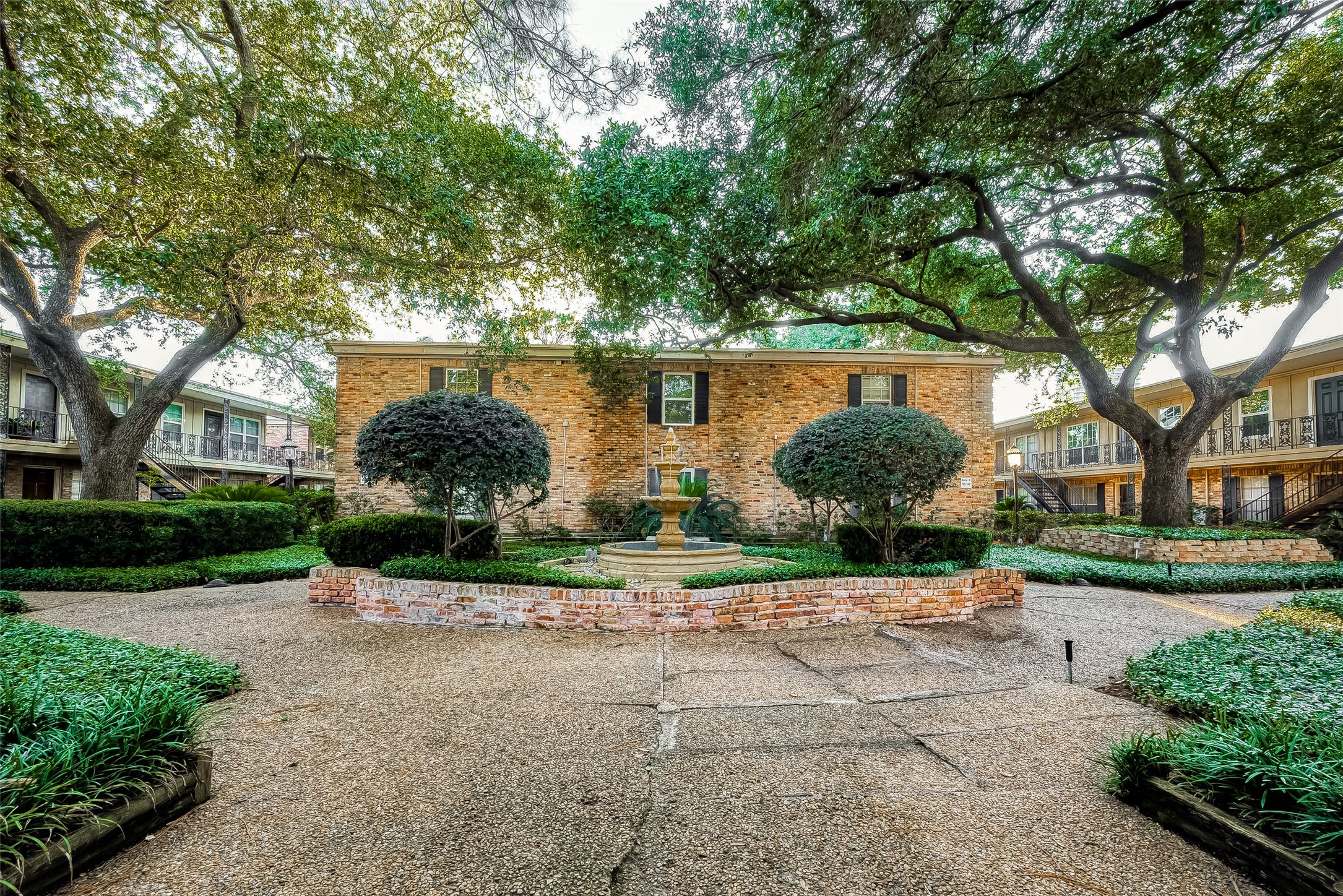 3224 Timmons Lane, Unit 147 Houston, TX 77027 - Photo 4 of 32 a backyard of a house with lots of green space and fountain