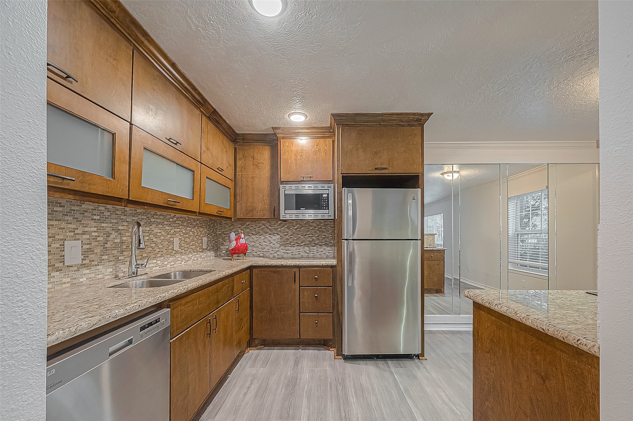3224 Timmons Lane, Unit 147 Houston, TX 77027 - Photo 9 of 32 a kitchen with a sink a refrigerator a counter space and cabinets