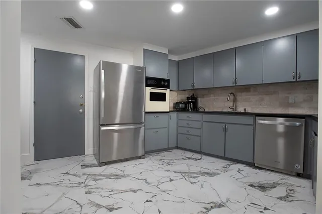 a kitchen with stainless steel appliances granite countertop a refrigerator sink and cabinets