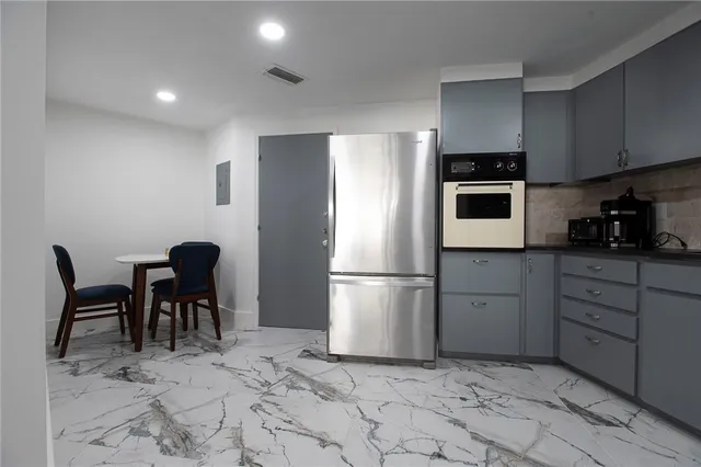 a kitchen with a dining table chairs and refrigerator