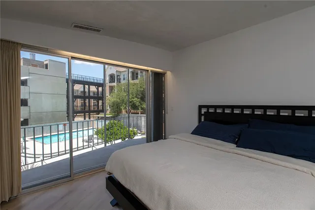 a bedroom with a large bed and a balcony