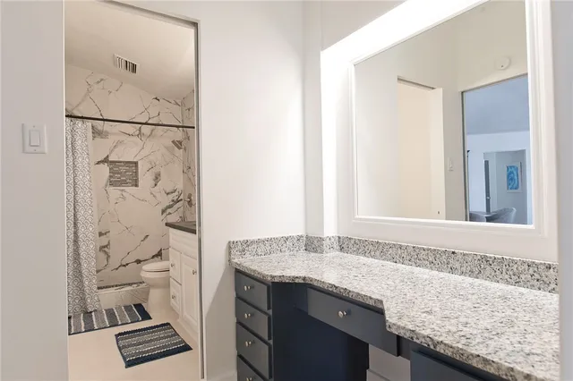 a bathroom with a granite countertop sink and a shower