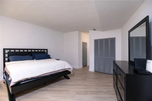 a bedroom with a bed and wooden floor