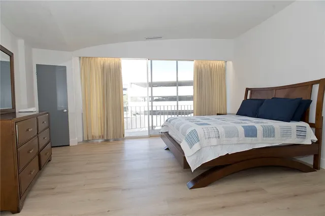 a bedroom with a bed and a large window