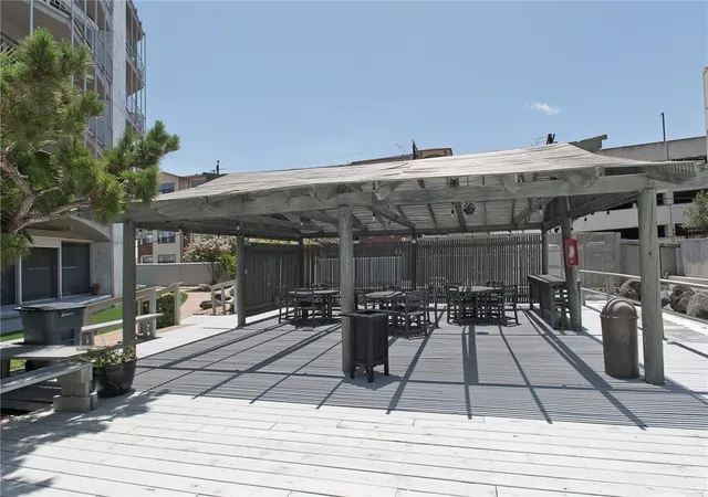 a view of a patio with table and chairs potted plants and floor to ceiling window and wooden floor