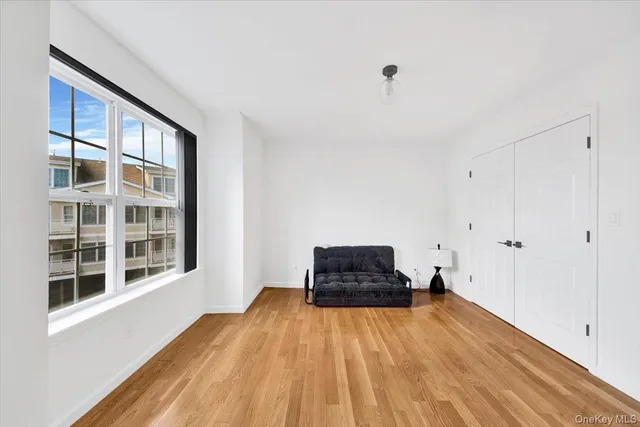 an empty room with a window and a wooden floor