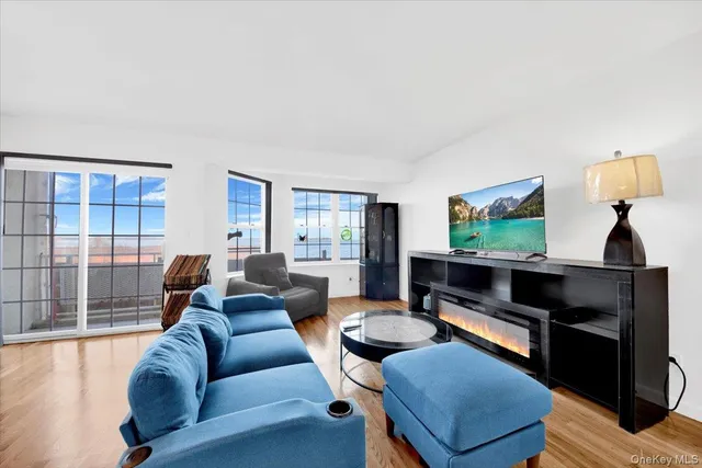 a living room with furniture a flat screen tv and a large window