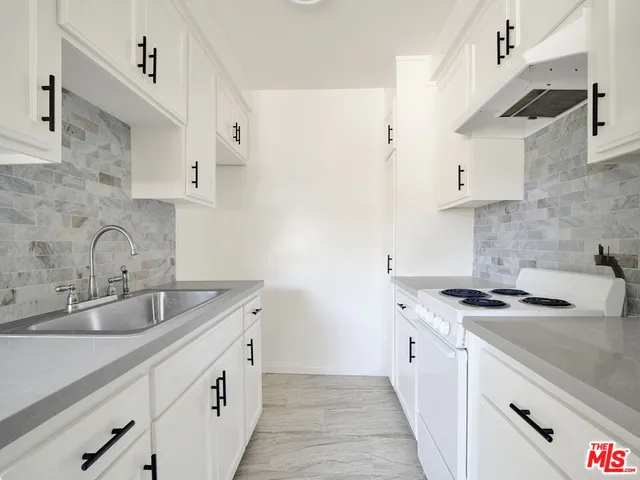 a kitchen with stainless steel appliances granite countertop a sink stove and cabinets