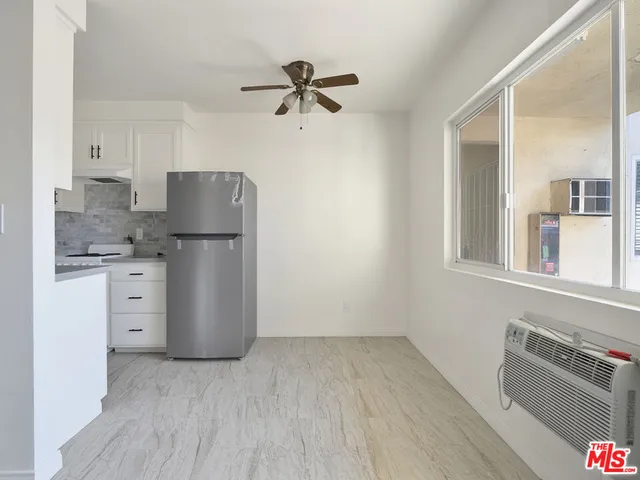 a kitchen with a refrigerator and white cabinets