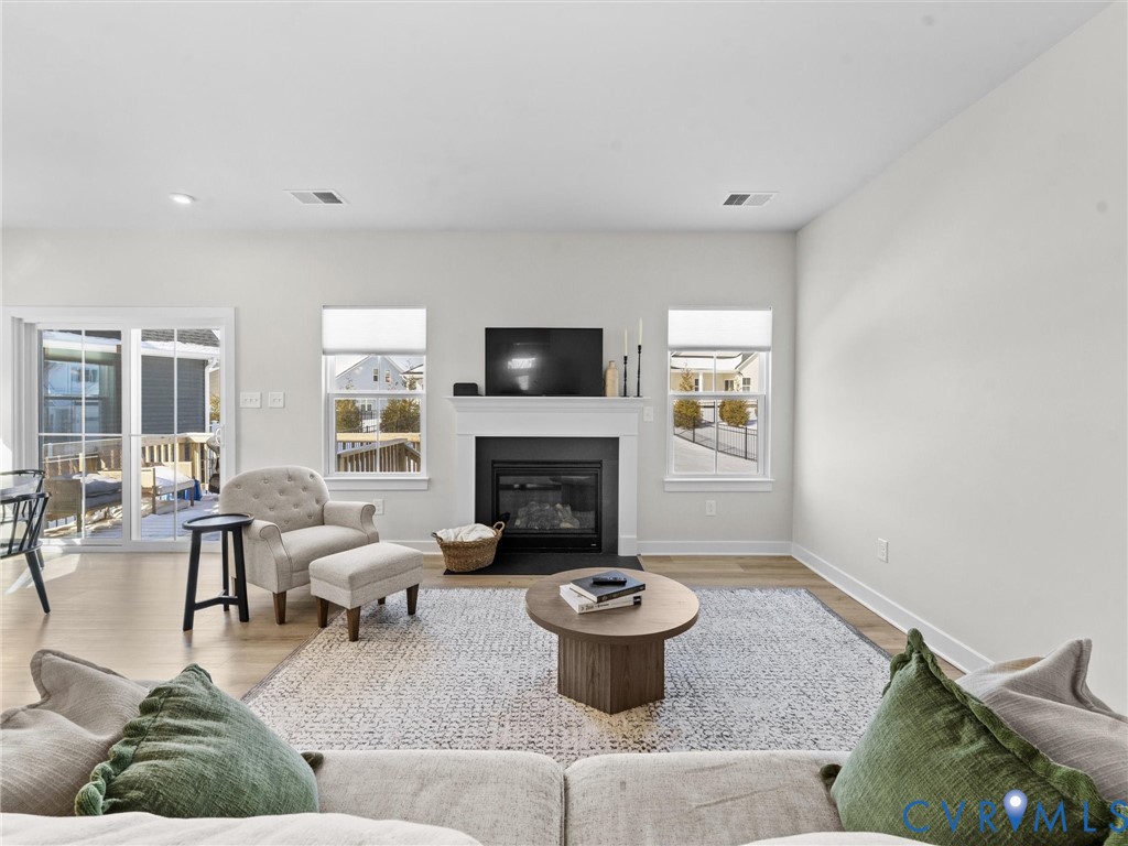 6230 Sheehan Crossing Moseley, VA 23120 - Photo 16 of 32 a living room with furniture a fireplace and a flat screen tv