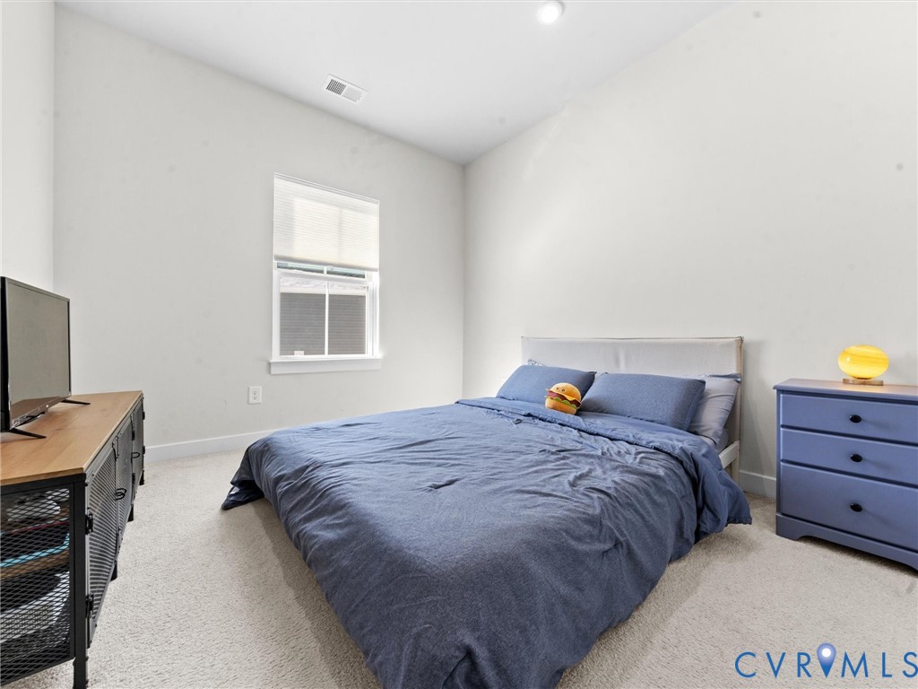 6230 Sheehan Crossing Moseley, VA 23120 - Photo 18 of 32 a bedroom with a bed and a flat tv screen on a dresser