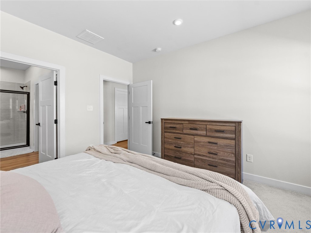 6230 Sheehan Crossing Moseley, VA 23120 - Photo 23 of 32 a bedroom with a bed and a mirror