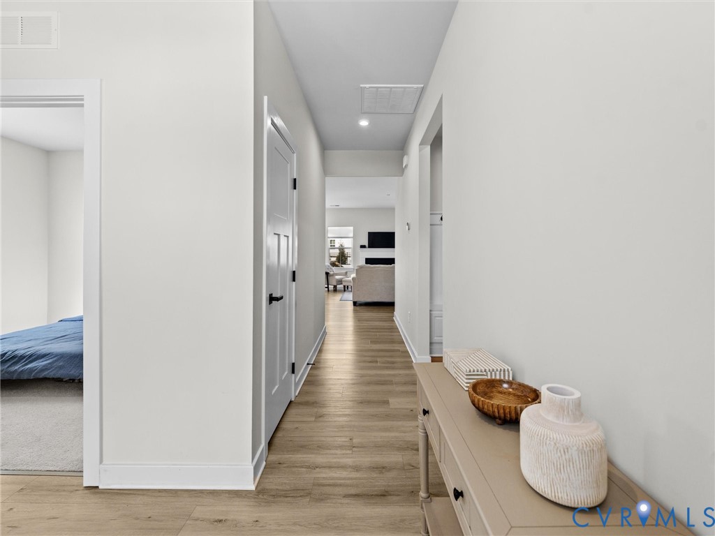 6230 Sheehan Crossing Moseley, VA 23120 - Photo 4 of 32 a view of a hallway with wooden floor and furniture