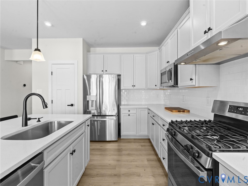 6230 Sheehan Crossing Moseley, VA 23120 - Photo 9 of 32 a kitchen with stainless steel appliances granite countertop a sink stove and refrigerator