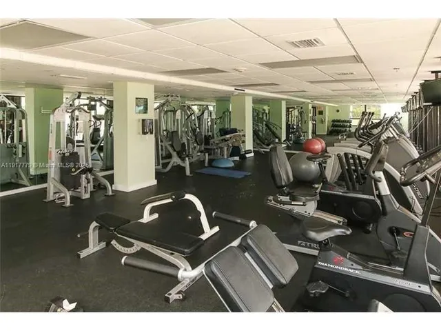 a room with gym equipment and large mirror