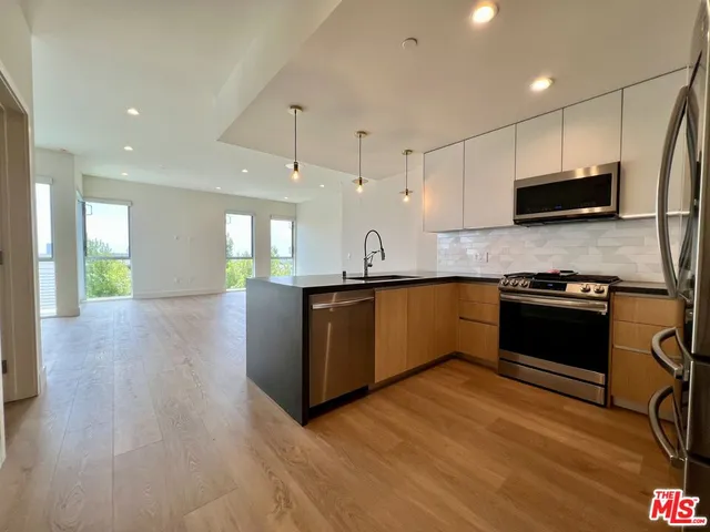 a kitchen with stainless steel appliances kitchen island granite countertop a stove a sink and a microwave