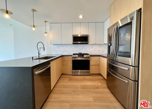 a kitchen with stainless steel appliances granite countertop a stove a sink dishwasher a refrigerator and a microwave oven