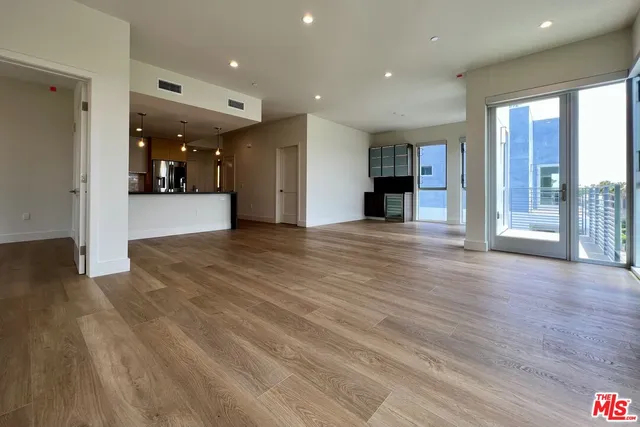 a view of a living room and kitchen with furniture and wooden floor