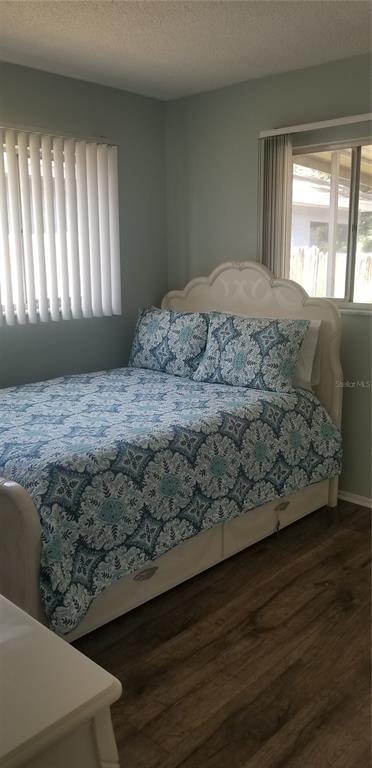 2334 Citrus Hill Road Palm Harbor, FL 34683 - Photo 4 of 7 a bedroom with a bed and wooden floor