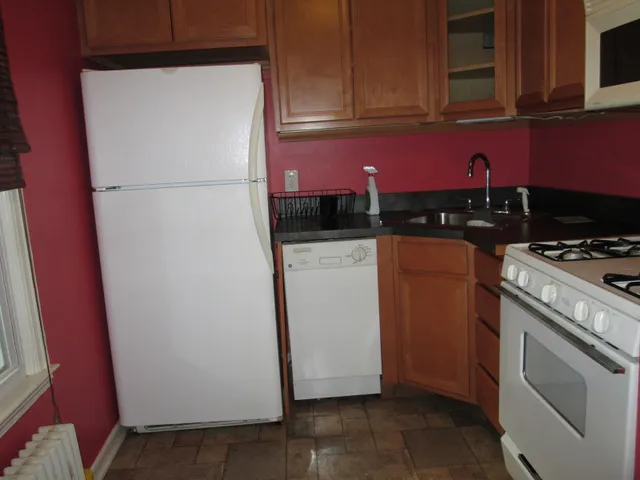 a kitchen with a refrigerator a stove top oven a sink and cabinets