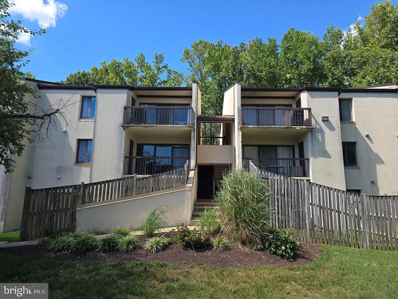 a front view of house with yard and trees in the background