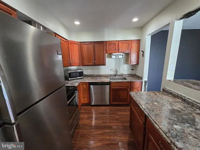 a kitchen with stainless steel appliances granite countertop a stove a sink and a refrigerator