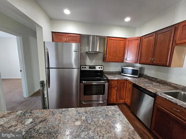 a kitchen with a refrigerator sink and cabinets