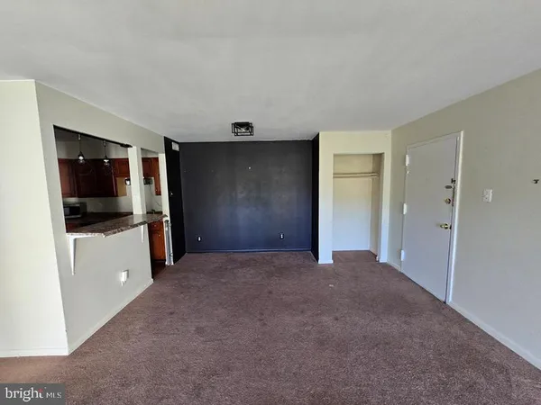 a view of a kitchen with a sink and an empty room