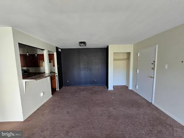 a view of a kitchen with a sink and an empty room