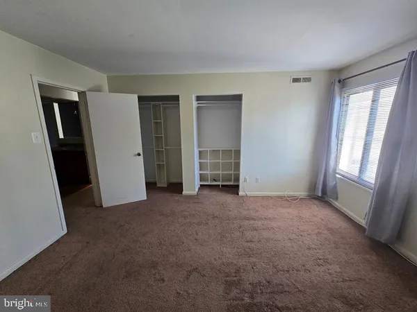 an empty room with windows and closet