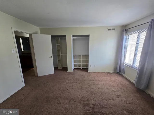 an empty room with windows and closet