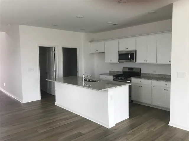 a kitchen with kitchen island a white counter top space and cabinets