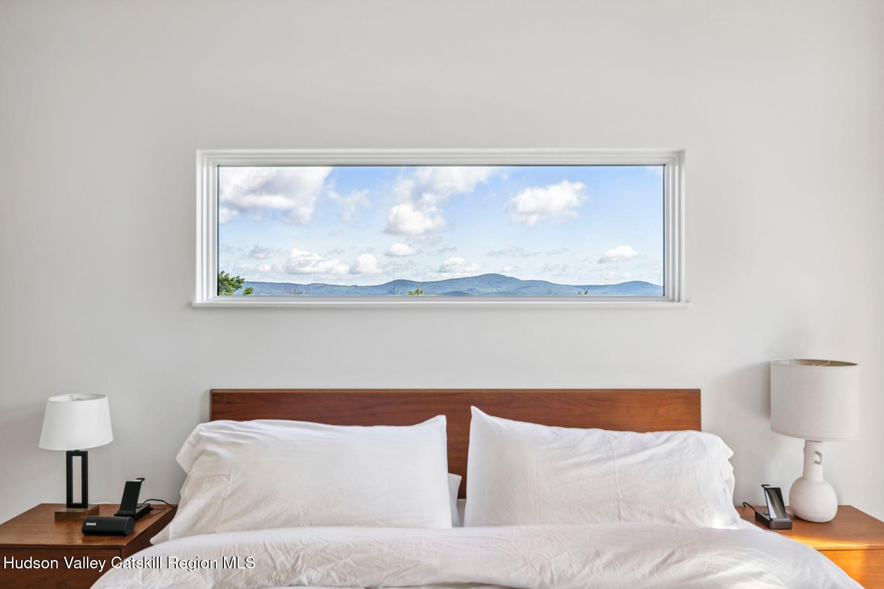 219 Club Road Windham, NY 12496 - Photo 36 of 103 a bedroom with a bed and a painting on the wall