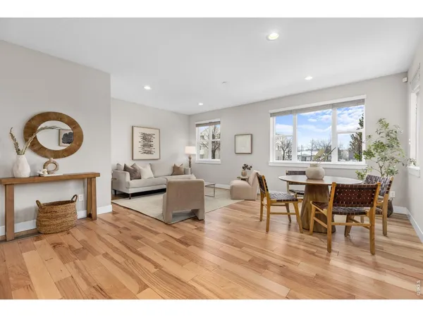 a living room with furniture a dining table and wooden floor