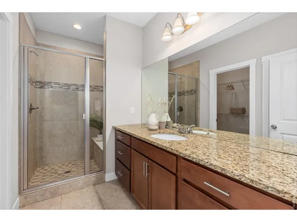 a bathroom with a granite countertop sink mirror and shower