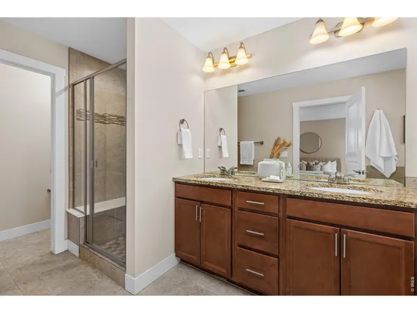 a bathroom with a granite countertop sink a mirror and a shower