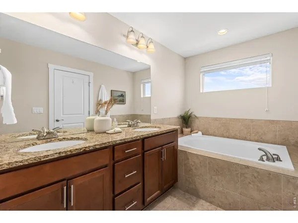 a bathroom with a granite countertop sink mirror and bathtub