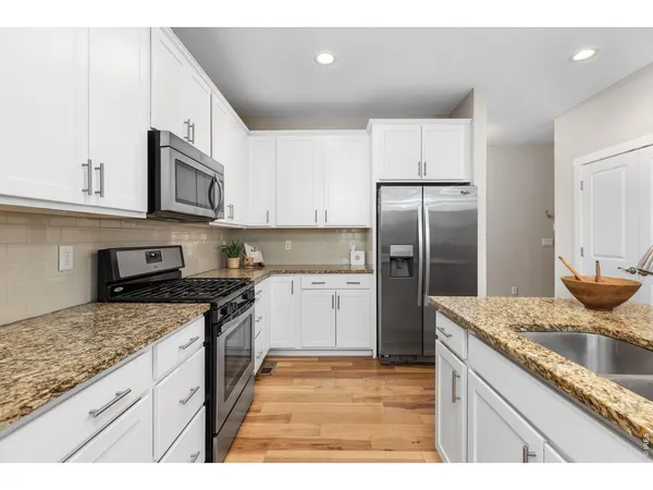 a kitchen with granite countertop a sink stove and refrigerator