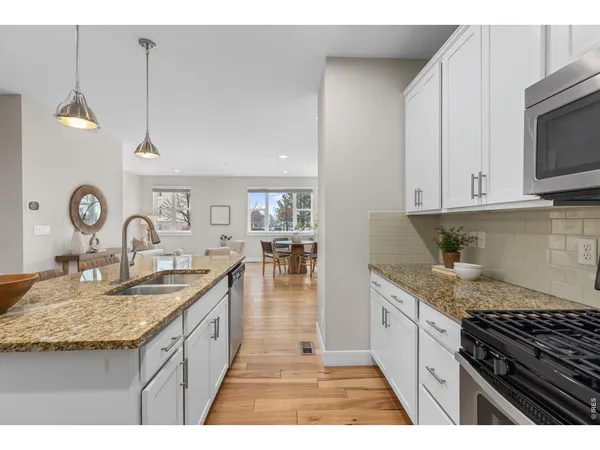 a kitchen with granite countertop a sink a stove and cabinets