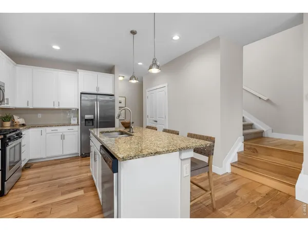 a kitchen with a sink a counter top space stainless steel appliances and cabinets
