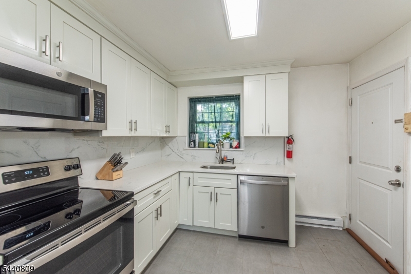 206 Main Street, Unit 42A Millburn, NJ 07041 - Photo 8 of 21 a kitchen with a sink stove and microwave