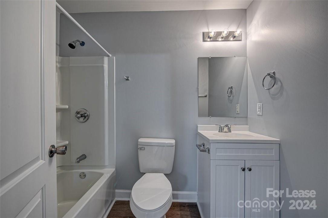 1024 Avondale Road, Unit 4 Lowell, NC 28098 - Photo 11 of 11 a bathroom with a toilet a sink a tub and mirror
