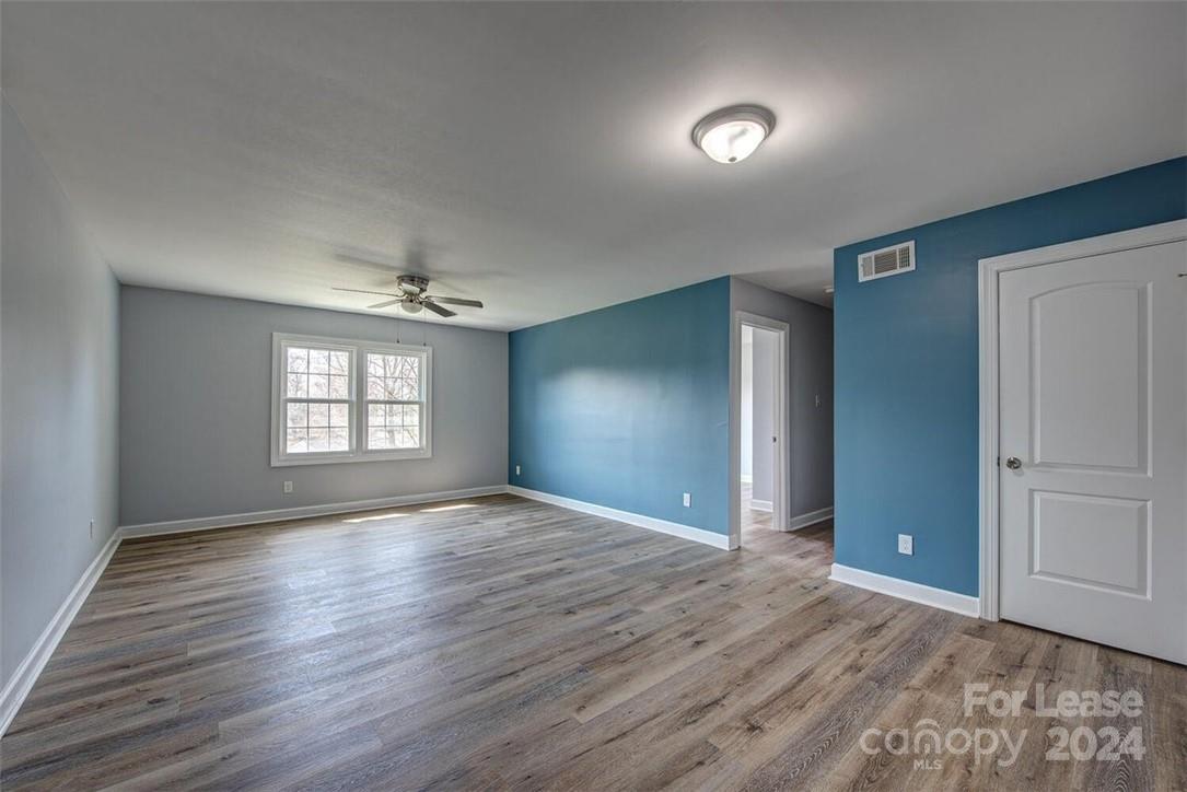 1024 Avondale Road, Unit 4 Lowell, NC 28098 - Photo 6 of 11 an empty room with wooden floor and windows