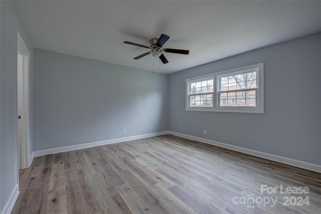 1024 Avondale Road, Unit 4 Lowell, NC 28098 - Photo 10 of 11 an empty room with wooden floor ceiling fan and windows