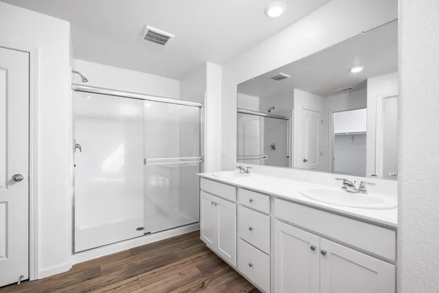 a spacious bathroom with a double vanity sink mirror and shower